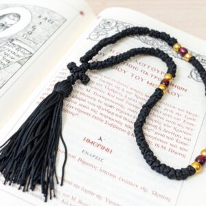 Traditional Prayer Rope 100 Knots featuring 100 tightly hand-tied knots in classic black cord, lustrous blue beads flanked by polished gold spacers, a hand-knotted cross, and a full matching tassel. Woven according to Orthodox traditions for daily prayer. Design: 100 traditional knots with blue beads and gold spacers Details: Hand-tied cross and flowing matching tassel Cord Color: Classic Black Origin: Handmade in Greece, Orthodox Monastic Craftsmanship